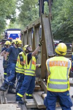 Construction of a temporary bridge over a slipped road crossing a stream, by the bridge