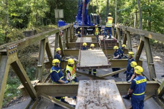 Construction of a temporary bridge over a slipped road crossing a stream, by the bridge
