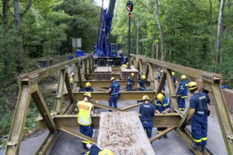 Construction of a temporary bridge over a slipped road crossing a stream, by the bridge