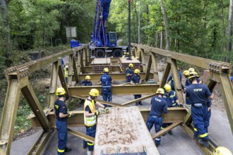 Construction of a temporary bridge over a slipped road crossing a stream, by the bridge