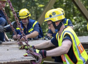 Construction of a temporary bridge over a slipped road crossing a stream, by the bridge