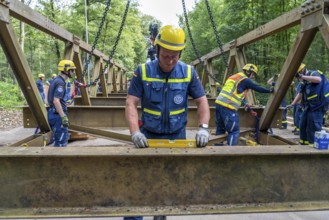Construction of a temporary bridge over a slipped road crossing a stream, by the bridge