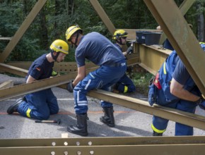 Construction of a temporary bridge over a slipped road crossing a stream, by the bridge