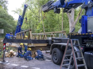 Construction of a temporary bridge over a slipped road crossing a stream, by the bridge