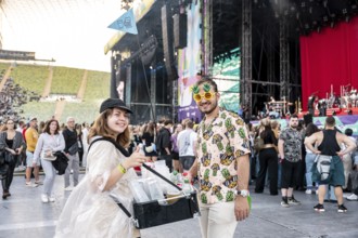 Man in pineapple sunglasses and pineapple shirt with female drinks vendor at Superbloom Festival,