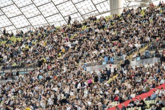 Festival visitors sitting in the stands in the Olympic Stadium at the Superbloom Festival, Day 1 in