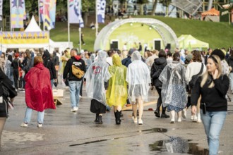 Festival visitors with rain capes at the Superbloom Festival, Day 1 in the Olympic Park, Munich,