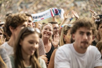 Visitor waving into camera at the Superbloom Festival, Day 1 in the Olympic Park, Munich,