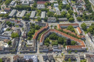 Aerial view, residential complex with red roofs and green trees in the inner courtyard on
