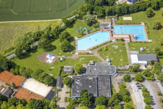 Aerial view, outdoor and indoor swimming pool HeljensBAD with sunbathing lawn, tennis facility of