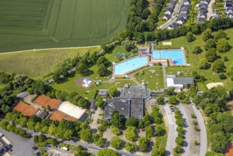 Aerial view, outdoor and indoor swimming pool HeljensBAD with sunbathing lawn, tennis facility of