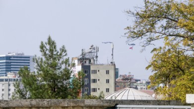 Türkiye special operations police hang from a helicopter with ropes, carrying weapons and unfurling