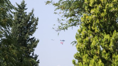 Türkiye special operations police hang from a helicopter with ropes, carrying weapons and unfurling