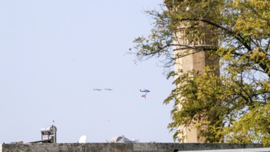 Türkiye special operations police hang from a helicopter with ropes, carrying weapons and unfurling