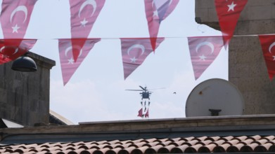 Türkiye special operations police hang from a helicopter with ropes, carrying weapons and unfurling