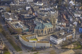 Aerial view, St. Urbanus Catholic Church and church square, commercial buildings and shopping
