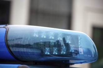 Symbolic image of a police operation: close-up of a flashing blue light on a police car
