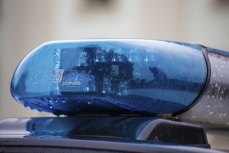 Symbolic image of a police operation: close-up of a flashing blue light on a police car