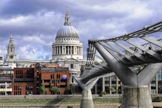 St Paul's Cathedral next to the Millennium Bridge under a dramatic sky, London, England, United