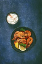 Fried white-footed shrimp, tiger prawns vannamey, on a plate, with lemon and herbs, no people