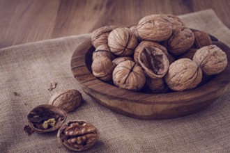 Freshly picked walnuts, in a wooden bowl, on a wooden table, rustic style, no people