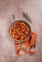 Meat goulash with potatoes and carrots, sweet peppers, in a saucepan, top view, traditional