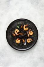 Black spaghetti with shrimp and mussels, on a black plate, spaghetti with shrimp, spaghetti with