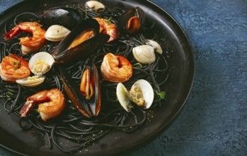 Black spaghetti, with shrimp and mussels, vongole, on a black plate, spaghetti with shrimp,