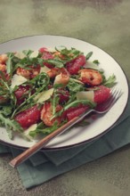 Fresh shrimp salad with arugula, grapefruit, and parmesan served in a bowl