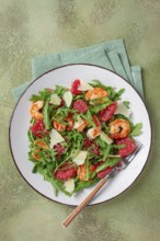 Fresh shrimp salad with arugula, grapefruit, and parmesan served in a bowl