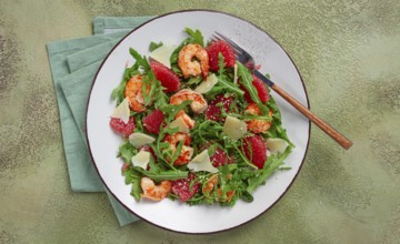 Fresh shrimp salad with arugula, grapefruit, and parmesan served in a bowl