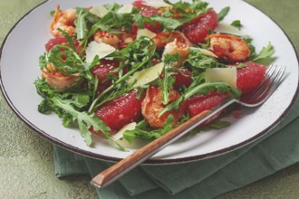 Fresh shrimp salad with arugula, grapefruit, and parmesan served in a bowl