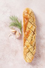 Freshly baked garlic bread with herbs and garlic on a light countertop