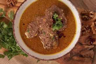 Fesenjan, an Iranian dish, stewed chicken, in a nut-pomegranate sauce, in a bowl, homemade, no