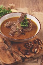 Fesenjan, an Iranian dish, stewed chicken, in a nut-pomegranate sauce, in a bowl, homemade, no