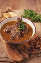 Fesenjan, an Iranian dish, stewed chicken, in a nut-pomegranate sauce, in a bowl, homemade, no