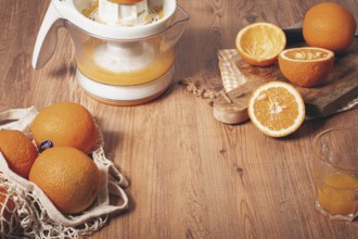 Preparation of freshly squeezed orange juice, using a juicer, in a cozy kitchen setting