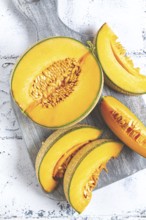 Freshly sliced melon slices, cantaloupe melon, on a wooden chopping board, close-up