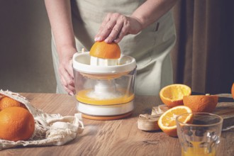 Preparation of freshly squeezed orange juice, using a juicer, in a cozy kitchen setting