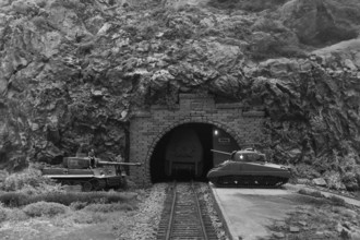 Diorama: Tiger and Sherman tanks in front of a mountain tunnel with tracks