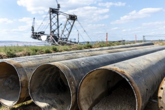Large excavator in open-cast mine with pipes in the foreground, Manheim, North Rhine-Westphalia,