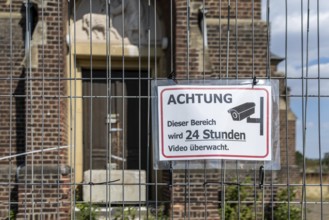 Warning sign Video surveillance in front of church behind fence, Manheim, North Rhine-Westphalia,