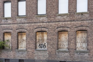 Old brick house façade with boarded-up windows, Manheim, North Rhine-Westphalia, Germany