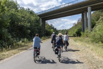 Group of cyclists under bridge at Hambach open-cast mine, Rhineland-Palatinate, Germany
