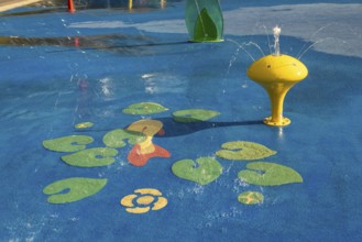Yellow water play equipment with water lily motif, green belt, Cologne