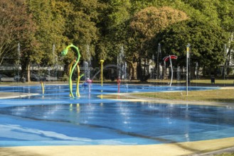 Panorama water playground with colourful play equipment, green belt, Cologne