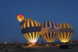 Several illuminated hot-air balloons decorate the sky at dawn, Göreme National Park, Göreme Tarihî