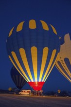 Various hot air balloons are prepared at night and light up the landscape, Göreme National Park,