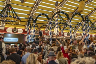 Visitors and band in the Löwenbräu marquee at the Oktoberfest 2024 in Munich, Bavaria, Germany
