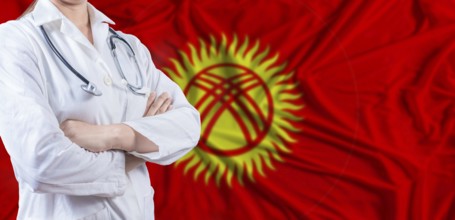 Doctor with crossed arms on Kyrgyzstan flag. Kyrgyzstan health and care concept. Female doctor on